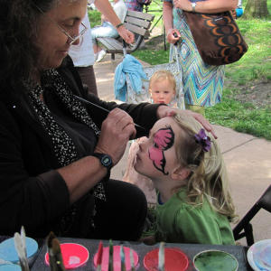 A woman paints a young girl’s face at the Live Oak Park Fair in Berkeley on April 19, 2012.